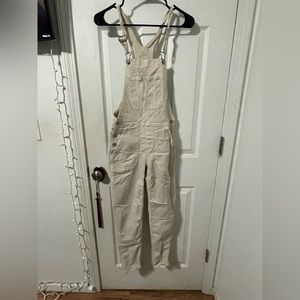 Tan overalls, with pockets.